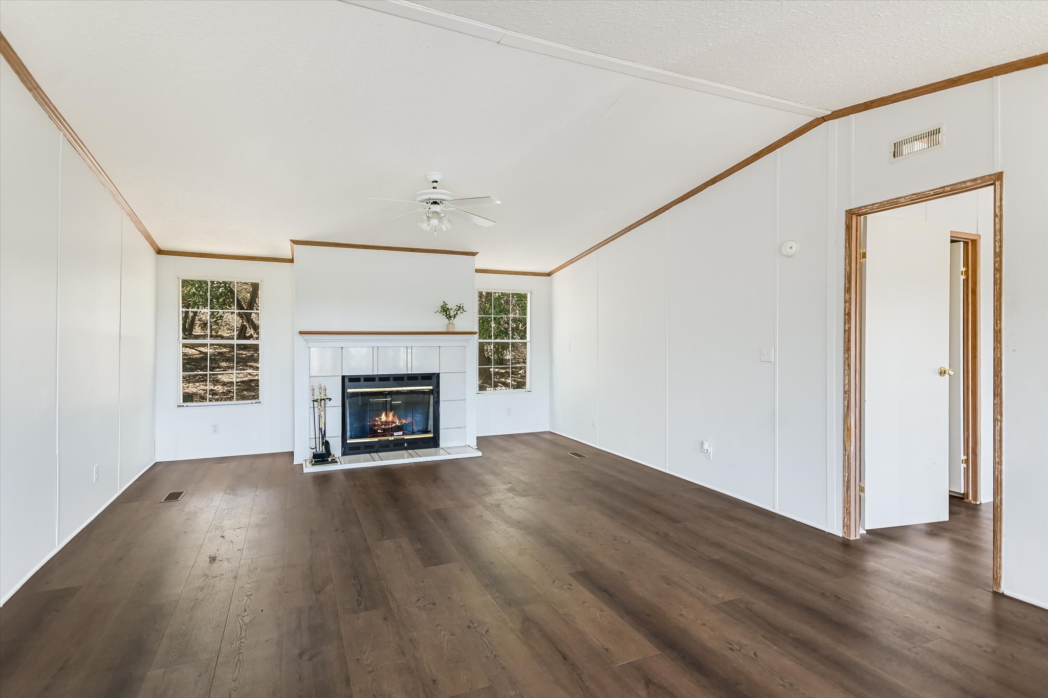 217 Rousey Street Canyon Lake, TX 78133 - Photo 10 of 25 a view of an empty room with wooden floor fireplace and a window