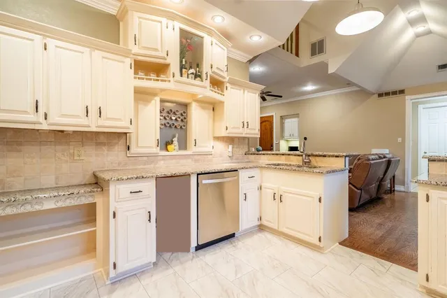 a kitchen with granite countertop a sink cabinets stainless steel appliances and a window