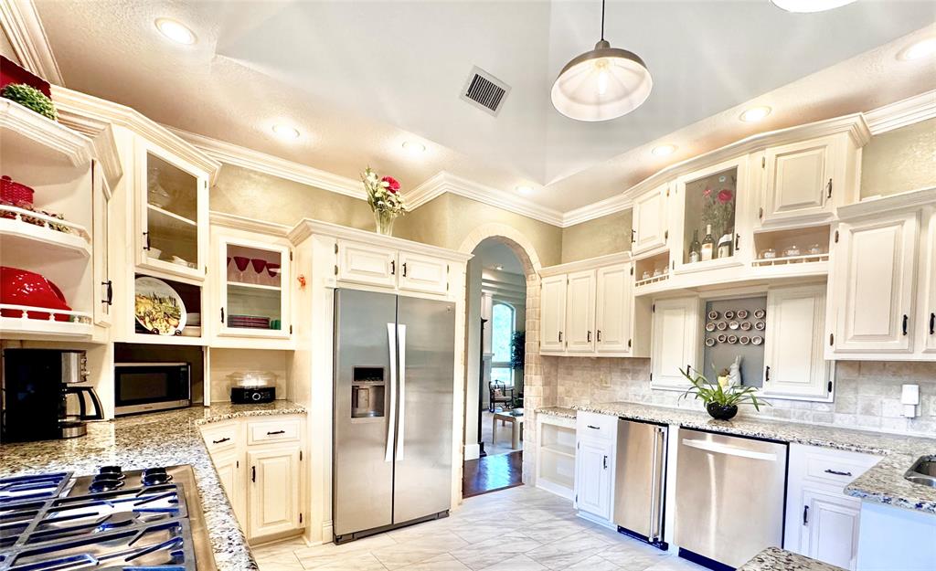 1450 Meandering Way Rockwall, TX 75087 - Photo 3 of 29 a kitchen with stainless steel appliances a stove a refrigerator and a sink