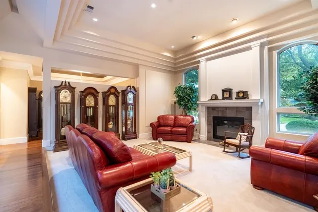 a living room with furniture a fireplace and a floor to ceiling window