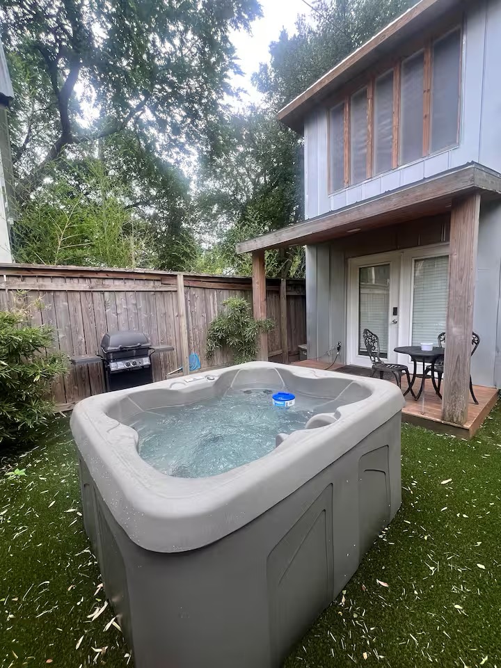 307 East 35th Street, Unit A Austin, TX 78705 - Photo 14 of 40 A private hot tub on a faux grass patio invites relaxation beside a charming two-story dwelling.