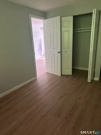 an empty room with wooden floor and a sink