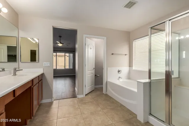 a spacious bathroom with a bathtub sink and mirror