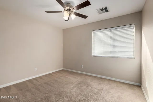 an empty room with a window and a fan