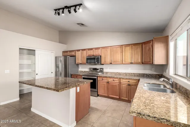 a kitchen with stainless steel appliances granite countertop a sink stove and refrigerator