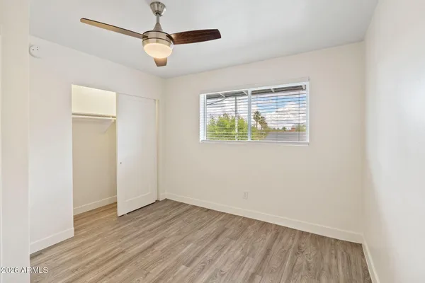 an empty room with a window and a ceiling fan