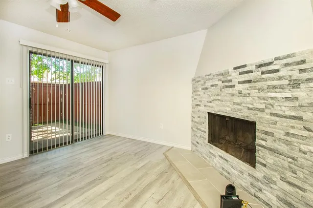 a view of empty room with wooden floor and fireplace