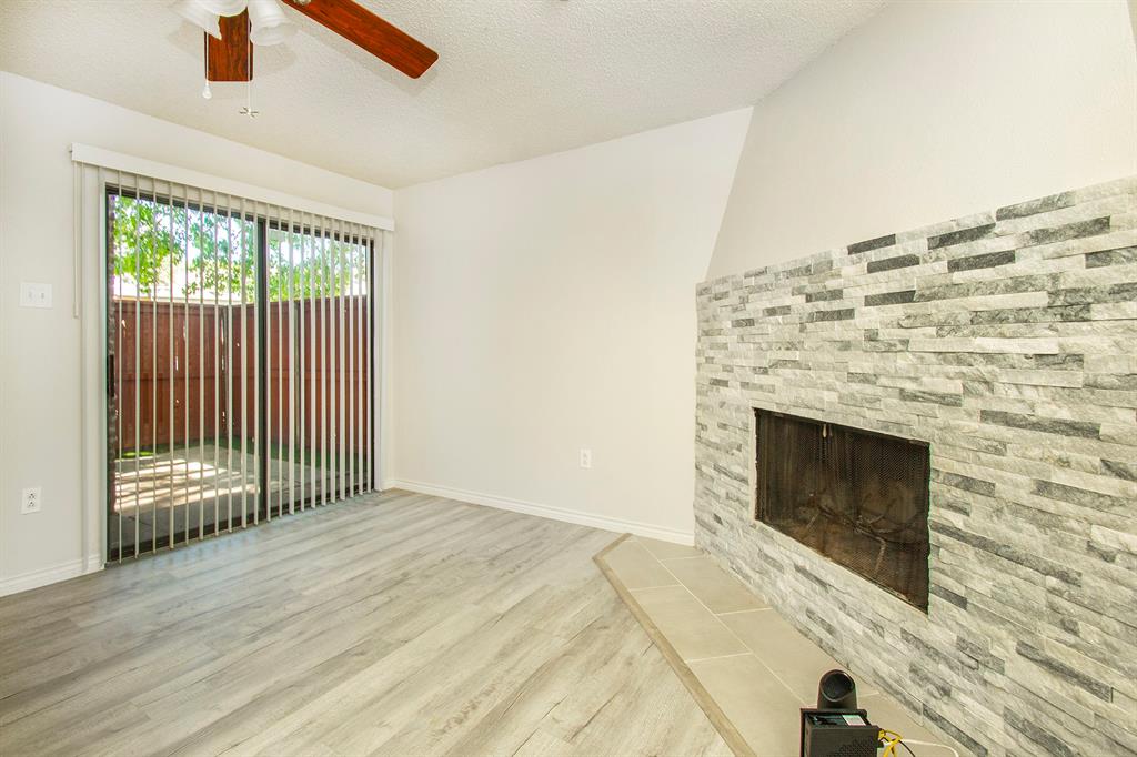 5626 Preston Oaks Road, Unit 9B Dallas, TX 75254 - Photo 12 of 20 a view of empty room with wooden floor and fireplace