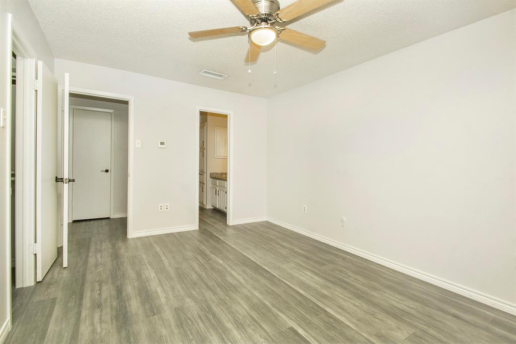 5626 Preston Oaks Road, Unit 9B Dallas, TX 75254 - Photo 13 of 20 an empty room with wooden floor fan and windows