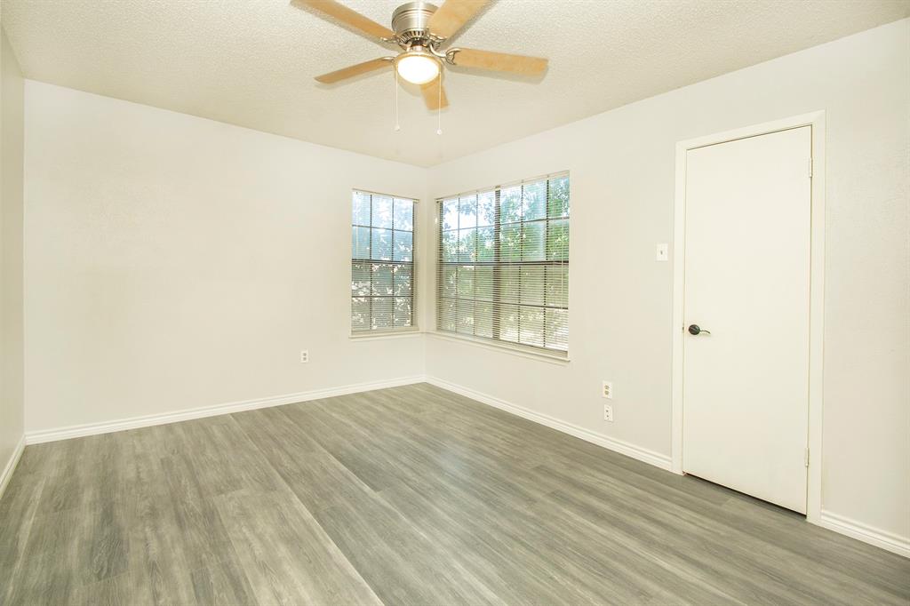5626 Preston Oaks Road, Unit 9B Dallas, TX 75254 - Photo 15 of 20 an empty room with wooden floor fan and windows