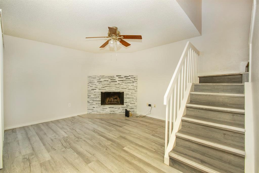 5626 Preston Oaks Road, Unit 9B Dallas, TX 75254 - Photo 5 of 20 a view of an empty room with wooden floor fireplace and a window
