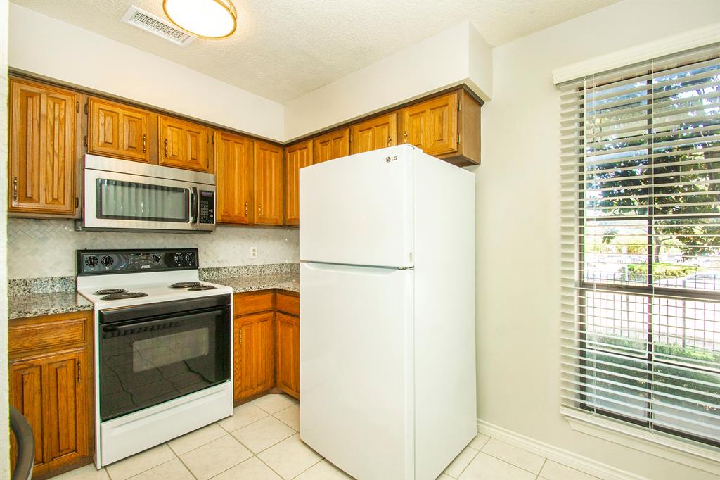 5626 Preston Oaks Road, Unit 9B Dallas, TX 75254 - Photo 7 of 20 a kitchen with a refrigerator a stove top oven and a sink