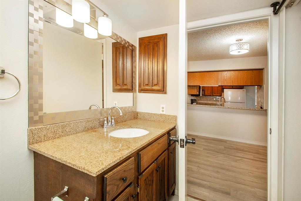 5626 Preston Oaks Road, Unit 9B Dallas, TX 75254 - Photo 10 of 20 a bathroom with a granite countertop sink a mirror and a shower