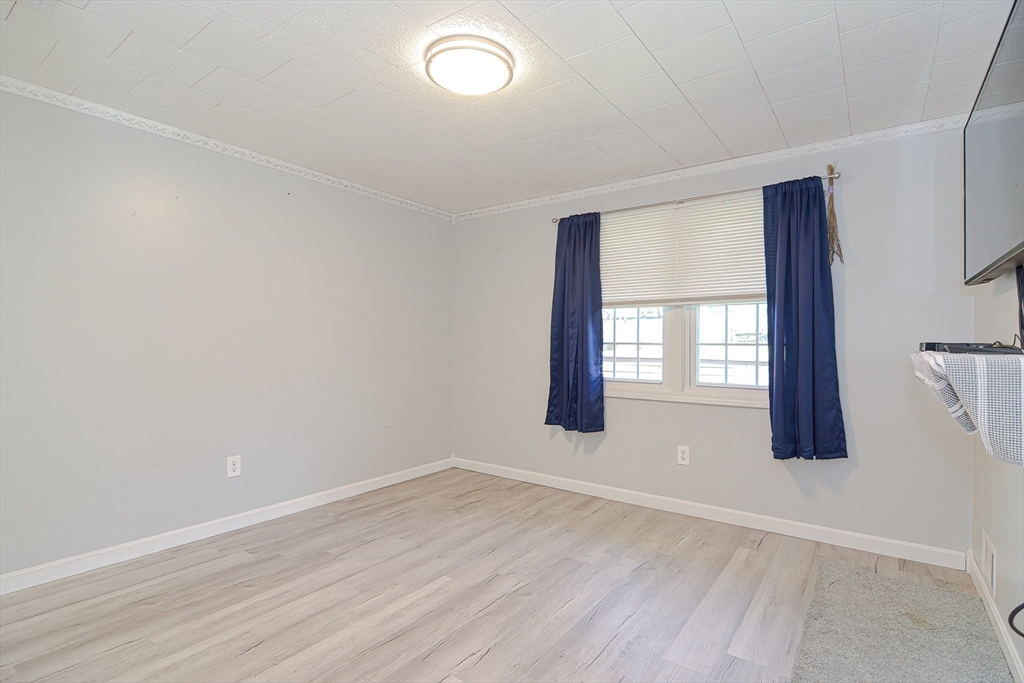 221 Smoke Rise Circle Swansea, MA 02777 - Photo 14 of 25 an empty room with wooden floor and windows