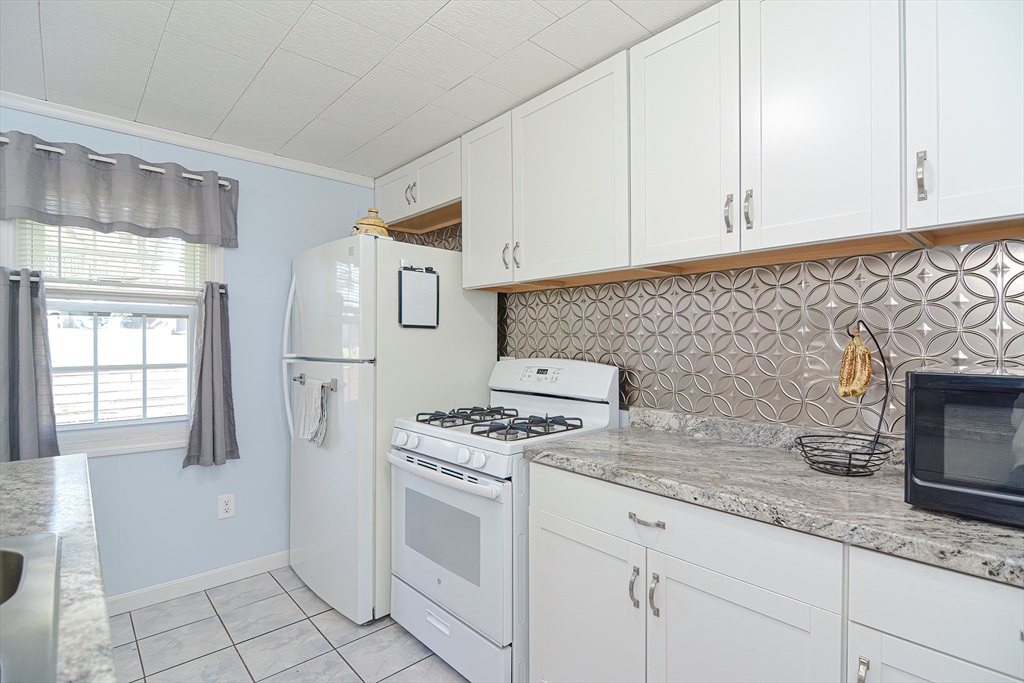 221 Smoke Rise Circle Swansea, MA 02777 - Photo 25 of 25 a kitchen with granite countertop white cabinets and white appliances