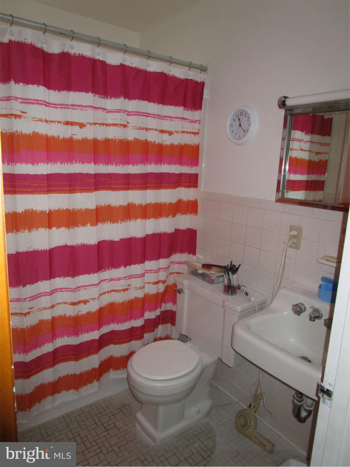 25331 Military Road Cascade, MD 21719 - Photo 8 of 13 a white toilet sitting next to a shower curtain