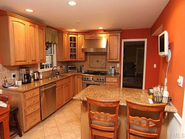 7819 Harps Mill Road Raleigh, NC 27615 - Photo 5 of 21 The spacious kitchen boasts beautiful cabinetry, granite countertops and stainless steel appliances Kitchen