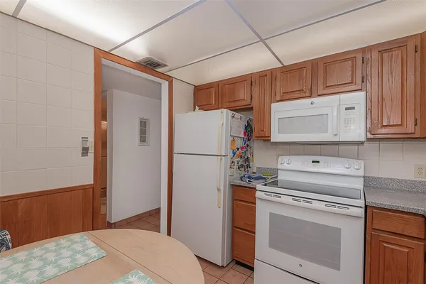 a kitchen with white cabinets and white appliances