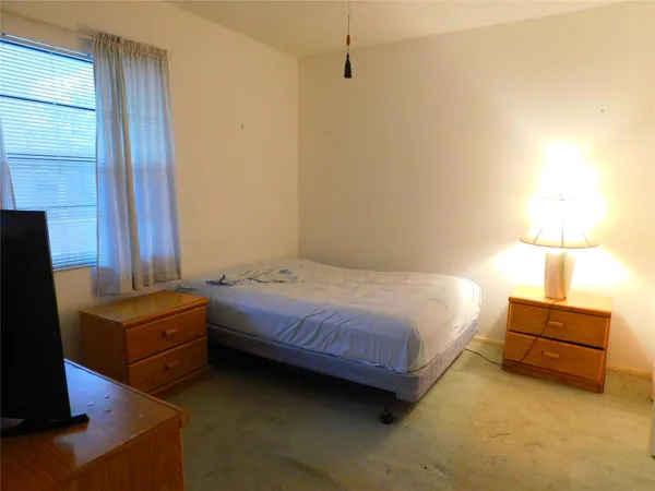 a bedroom with a bed and a flat tv screen on a dresser
