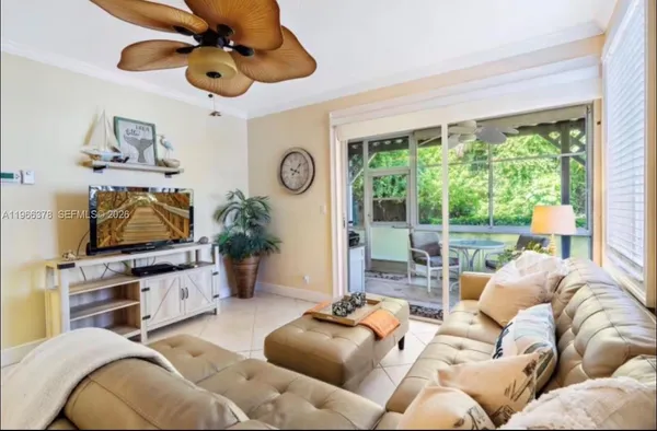 a living room with furniture a flat screen tv and a window