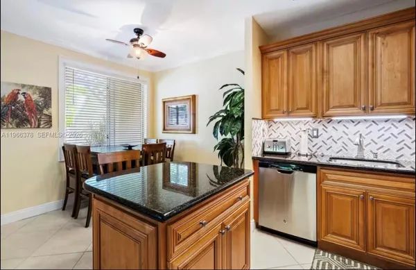 a kitchen with granite countertop a stove a sink dishwasher and cabinets with wooden floor