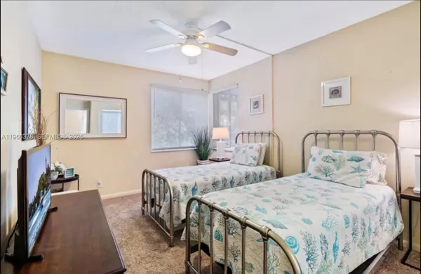 a bedroom with two beds and a chandelier