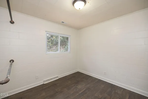 a view of a room with wooden floor and window
