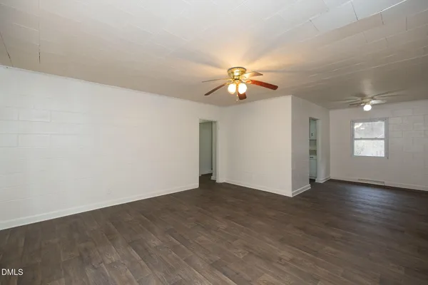 an empty room with wooden floor and window