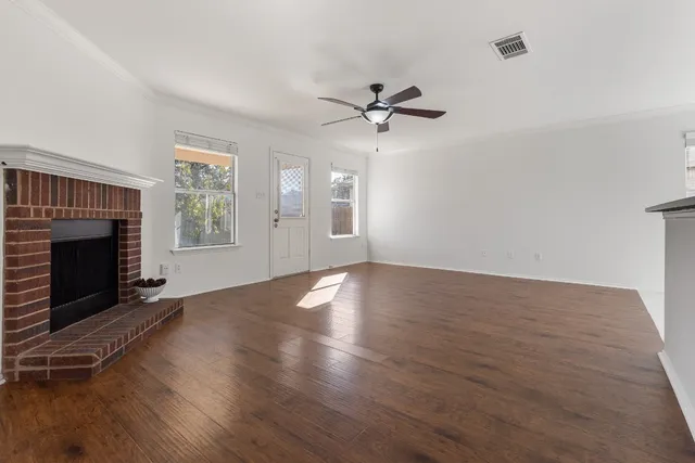 a view of empty room with wooden floor and fireplace