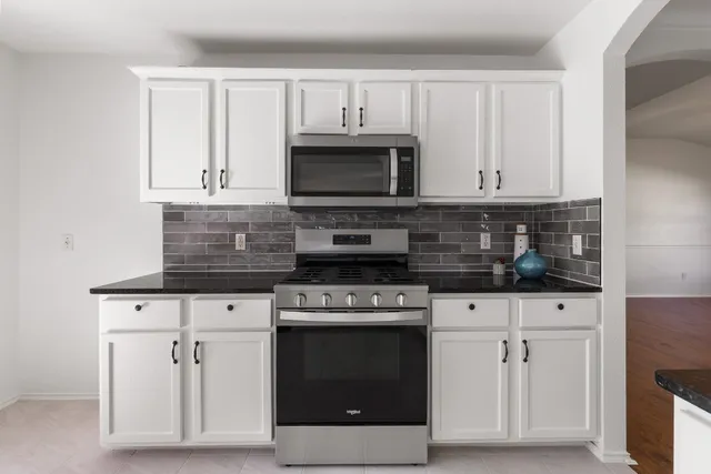 a kitchen with granite countertop a sink and a stove