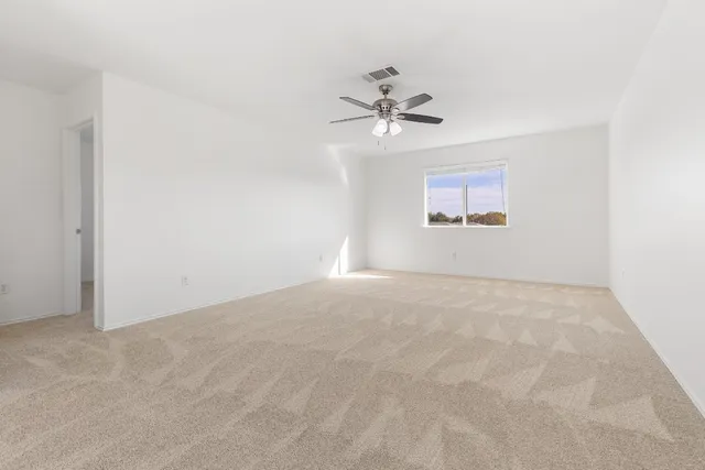 a view of empty room with ceiling fan