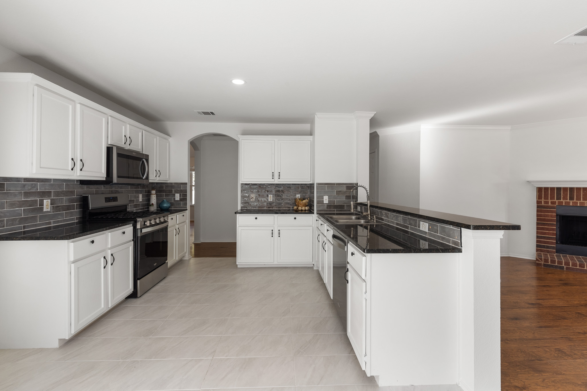 406 Golden Gate Drive Leander, TX 78641 - Photo 6 of 40 Kitchen featuring appliances with stainless steel finishes, white cabinetry, arched walkways, a peninsula, and recessed lighting