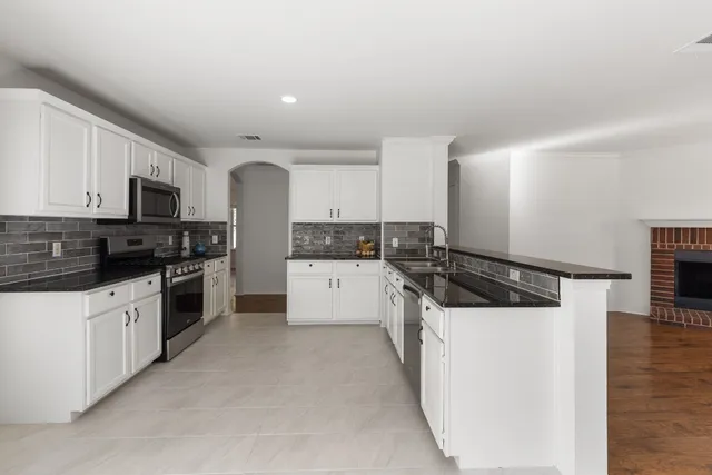 a kitchen with white cabinets and appliances