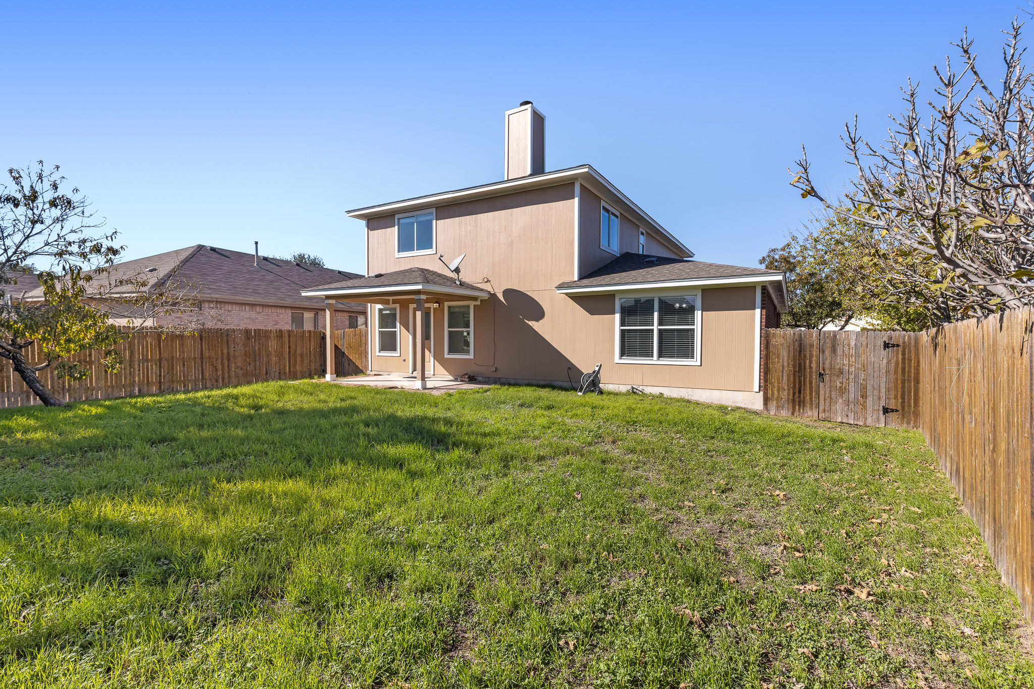 406 Golden Gate Drive Leander, TX 78641 - Photo 9 of 40 Back of property featuring a patio area, a fenced backyard, and a chimney