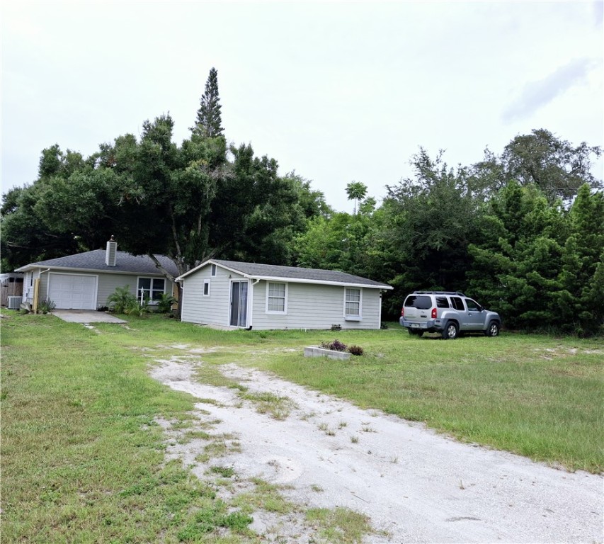 a front view of a house with a garden and trees