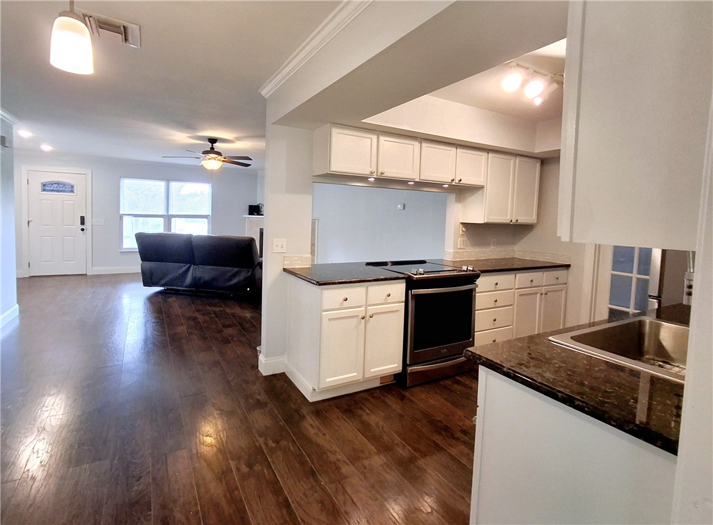 1110 10th Place Vero Beach, FL 32960 - Photo 7 of 18 a kitchen with granite countertop a stove and a wooden floors