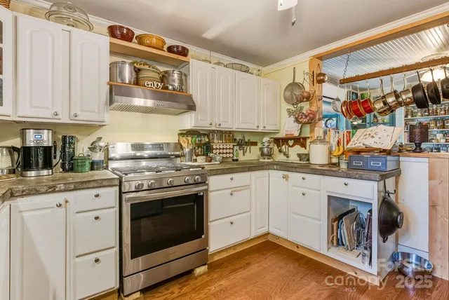 a kitchen with stainless steel appliances granite countertop a stove and white cabinets