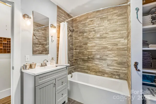 a bathroom with a granite countertop sink a mirror and a bathtub