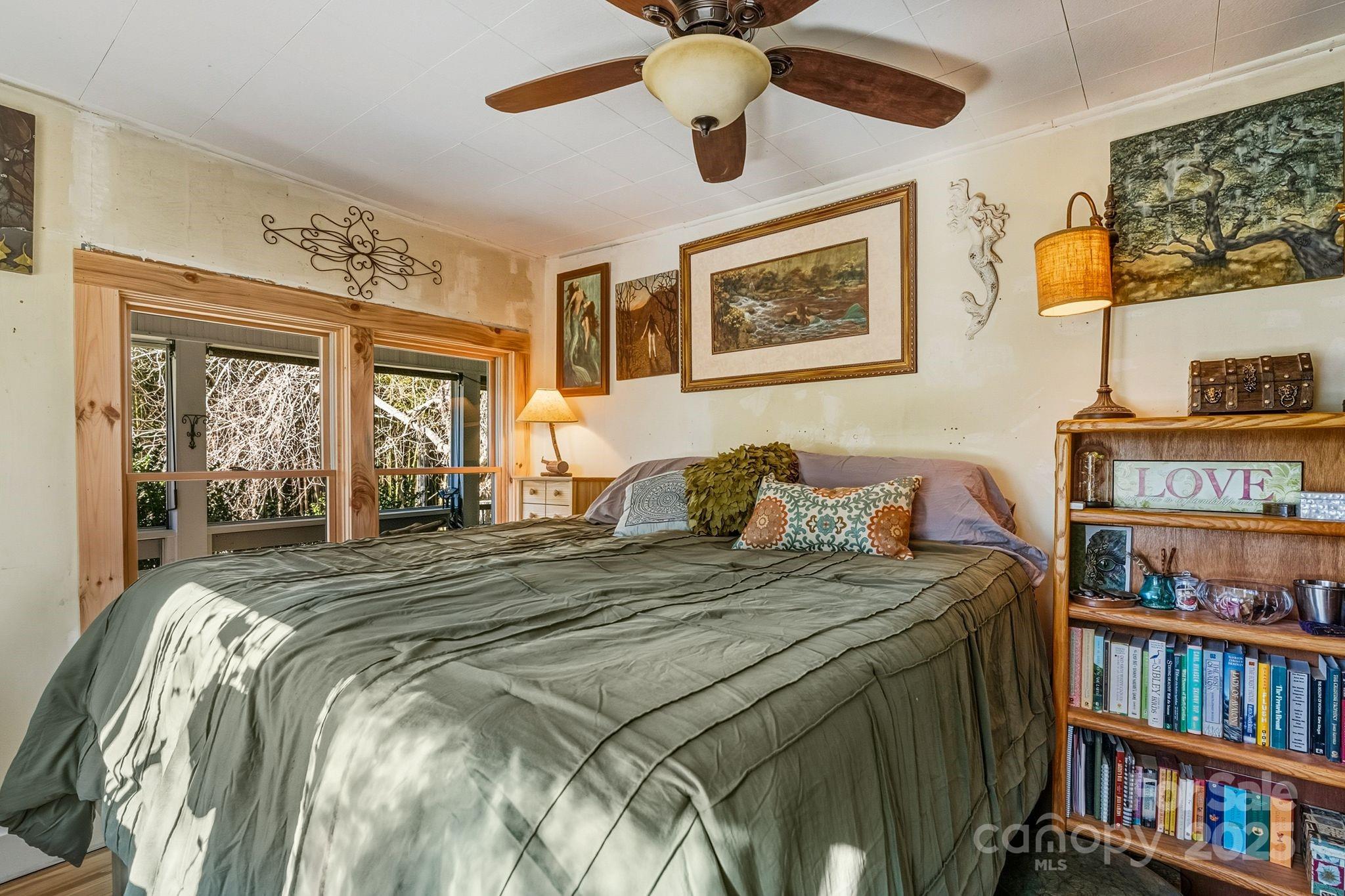 13 Holly Hill Farm Road Mars Hill, NC 28754 - Photo 16 of 44 a bed sitting in a bedroom next to a book shelf