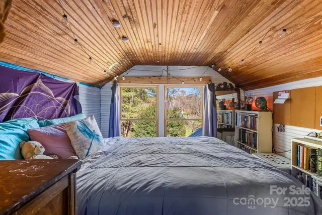 a bed sitting in a bedroom next to a window