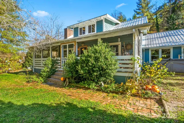 a view of a house with brick walls and a yard with plants