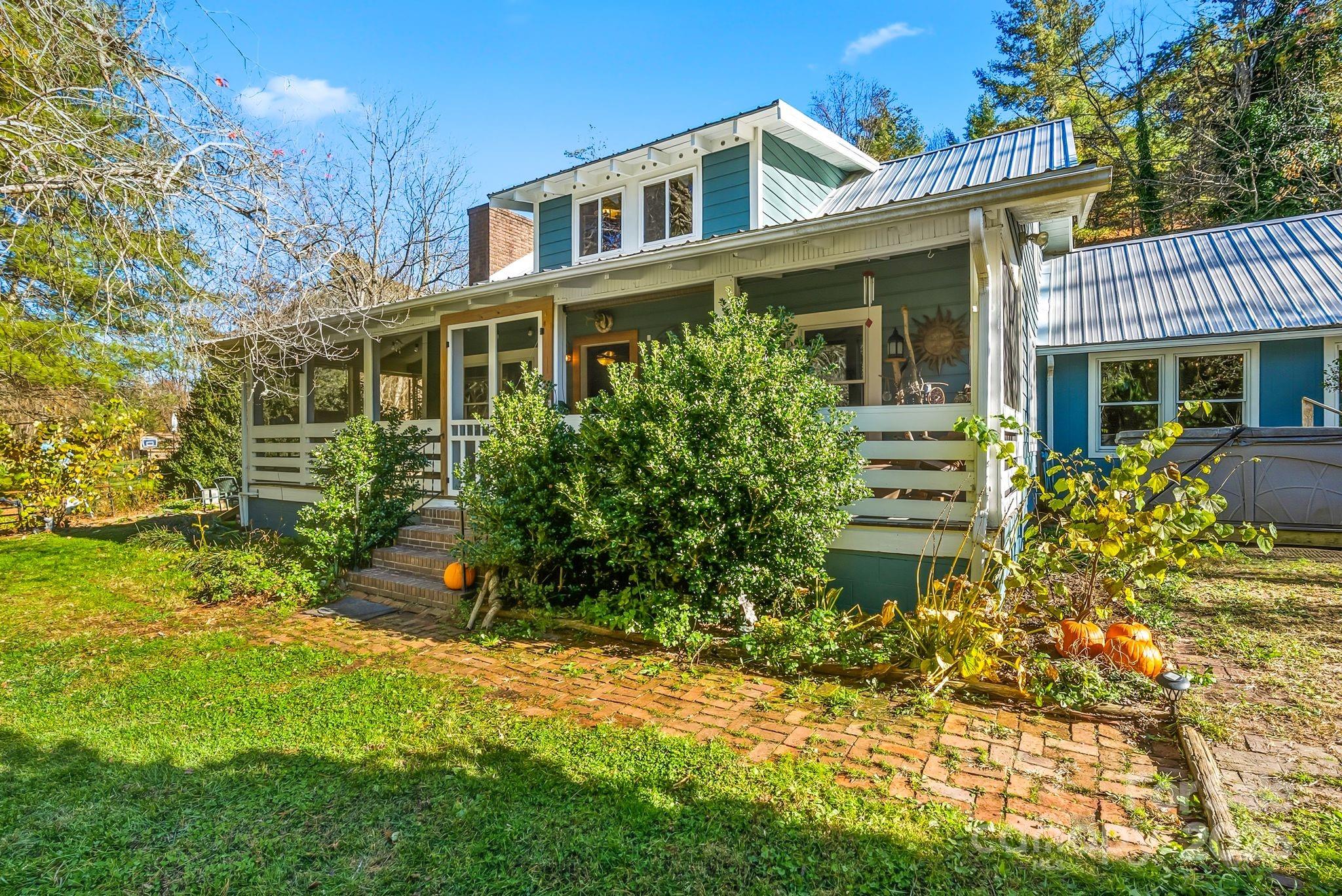 13 Holly Hill Farm Road Mars Hill, NC 28754 - Photo 2 of 44 a view of a house with brick walls and a yard with plants