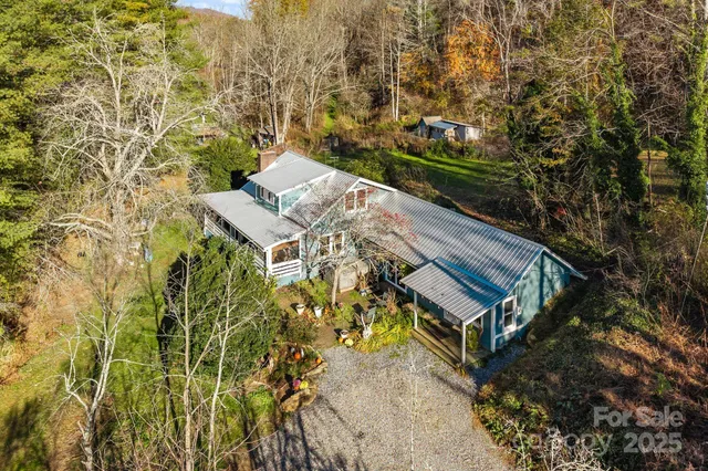 a view of a house with a yard and large trees