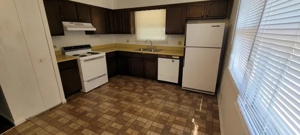 a kitchen with a sink a refrigerator and cabinets