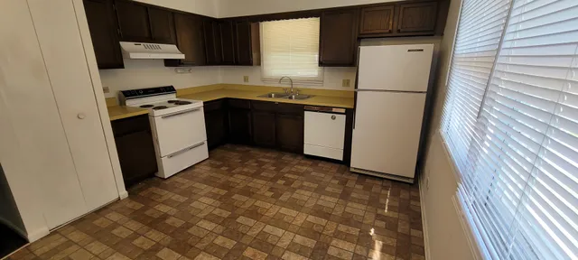 a kitchen with a sink a refrigerator and cabinets