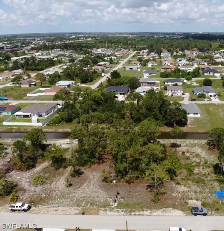 an aerial view of residential houses with outdoor space and trees