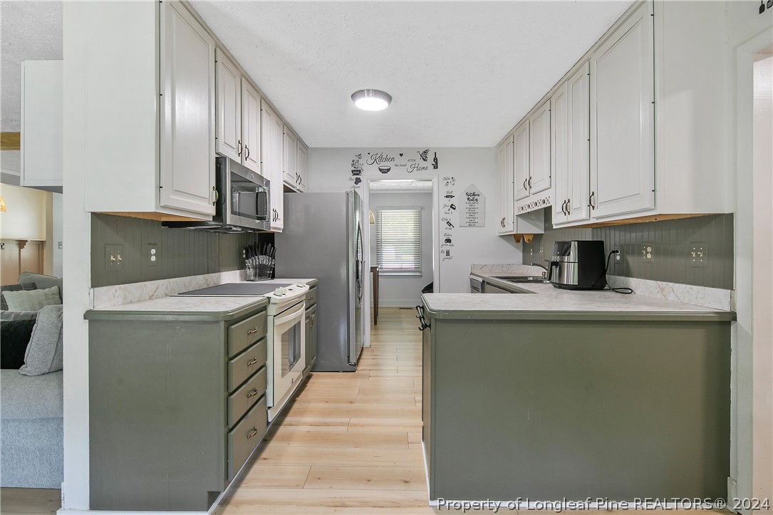 3011 Rouse Road Fayetteville, NC 28306 - Photo 20 of 50 a kitchen with granite countertop a sink and a refrigerator