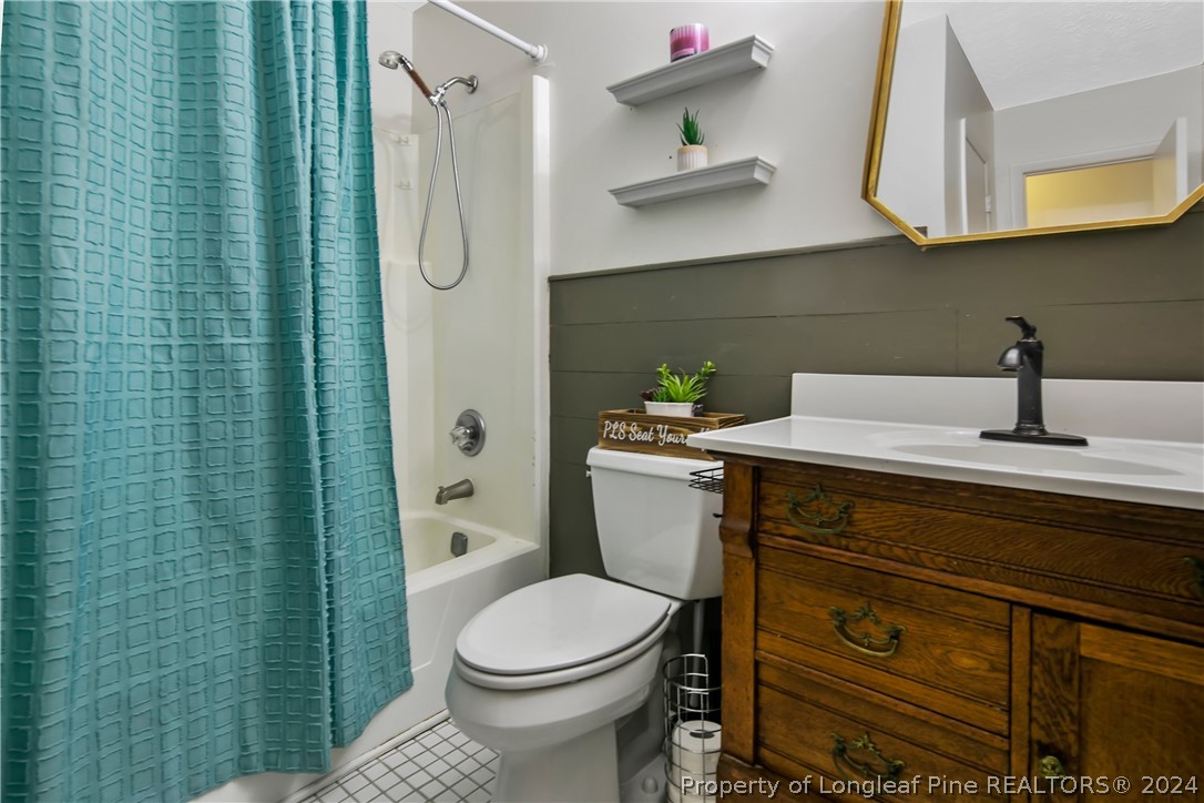 3011 Rouse Road Fayetteville, NC 28306 - Photo 39 of 50 a bathroom with a sink a toilet and shower curtain