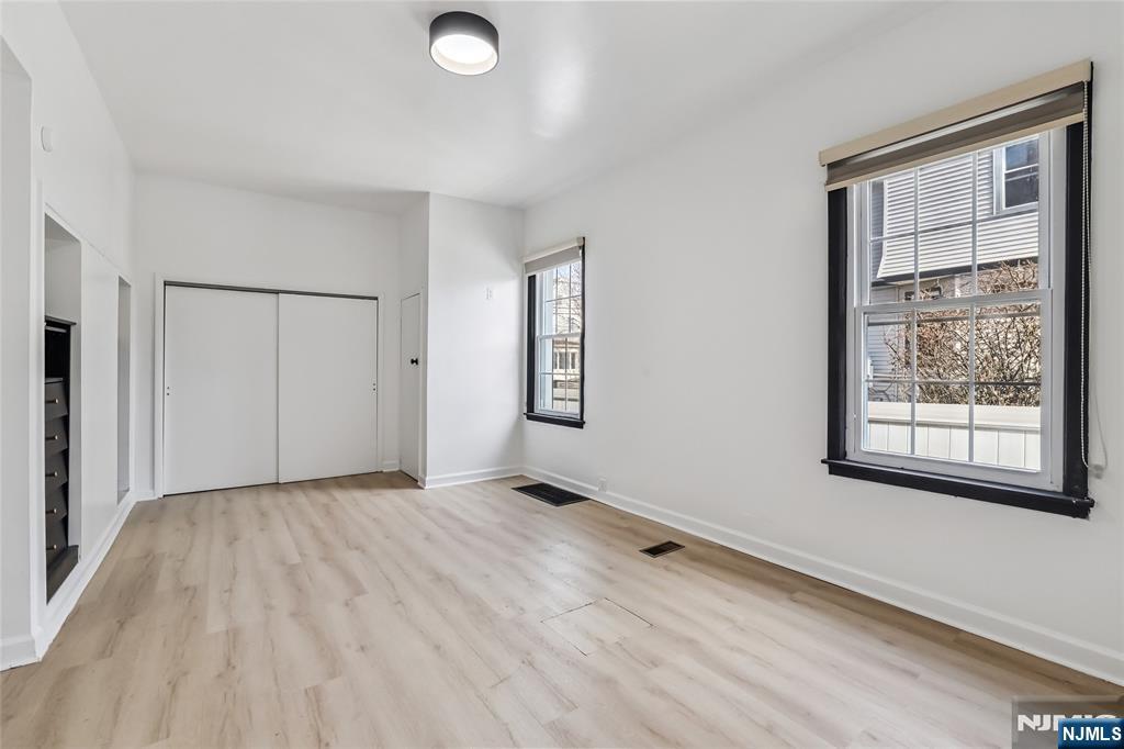 11 Garden Street, Unit 1 Ridgefield Park, NJ 07660 - Photo 13 of 20 a view of an empty room with a window and wooden floor
