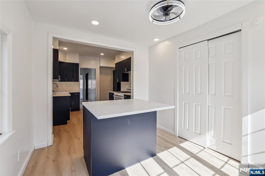 11 Garden Street, Unit 1 Ridgefield Park, NJ 07660 - Photo 4 of 20 a kitchen with kitchen island white cabinets and stainless steel appliances